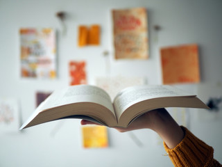 Open book on hand in teen room