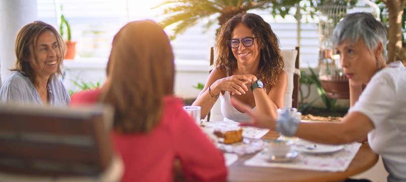 Young beautiful girl smiling happy and confident sitting dinking cup of coffee at terrace