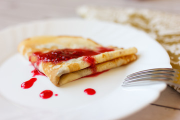Dessert with raspberry jam, roll appetizing pancakes