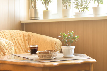 Unfinished cup of coffee on the old wooden table under the rays of the morning sun 