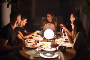 Beautiful family on dinner talking and smiling at terrace