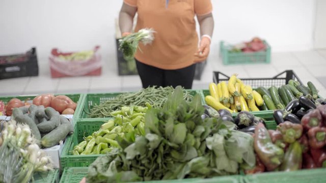 Commesso con frutta e verdura al mercato 