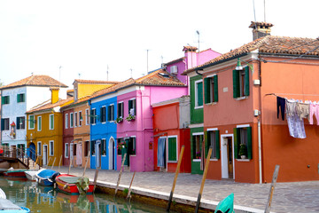 Colorful houses in Burano island. Canal view with boats. Travel photo. Venice. Italy. Europe.
