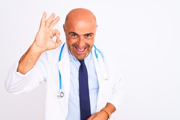 Middle age doctor man wearing stethoscope and tie standing over isolated white background smiling positive doing ok sign with hand and fingers. Successful expression.