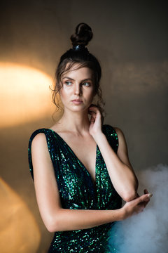 Young woman with smoke and movie light in a dark room