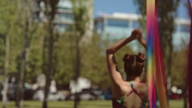 MUJER CORRIENDO CON CINTA COLORIDA EN UN PARQUE