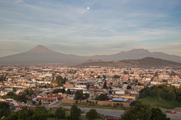 Fototapeta na wymiar Panoramic view of the city, Popocatepetl volcano, San Gabriel Convent, the city is famous for its Great Pyramid, the largest archaeological site in the world at its base