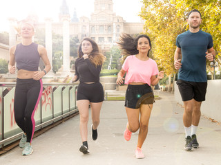 Healthy young man and women involved in a running event in a park at the beginning of Autumn