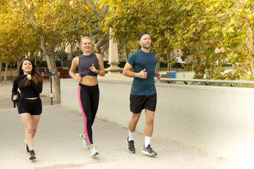 Young couple involved in a running event in a park at the beginning of Autumn