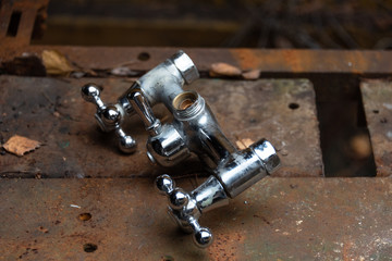 Old water mixing crane on a rusty metal workbench.