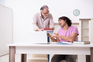 Old father helping his son in exam preparation