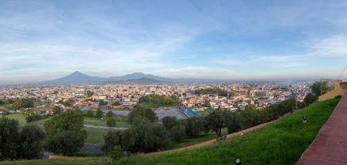 Obraz premium Panoramic view of the city, Popocatepetl volcano, San Gabriel Convent, the city is famous for its Great Pyramid, the largest archaeological site in the world at its base