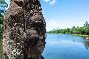 Angkor Thom, Cambodia, Stone face Asura over moat. 