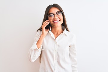 Young businesswoman wearing glasses talking on smartphone over isolated white background with a happy face standing and smiling with a confident smile showing teeth