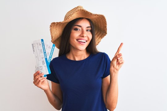 Young beautiful tourist woman holding boarding pass ticket over isolated white background very happy pointing with hand and finger to the side