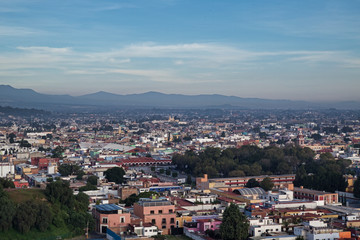 Fototapeta na wymiar Panoramic view of the city, Popocatepetl volcano, San Gabriel Convent, the city is famous for its Great Pyramid, the largest archaeological site in the world at its base