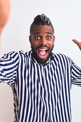 African american man with braids make selfie by camera over isolated white background very happy and excited, winner expression celebrating victory screaming with big smile and raised hands