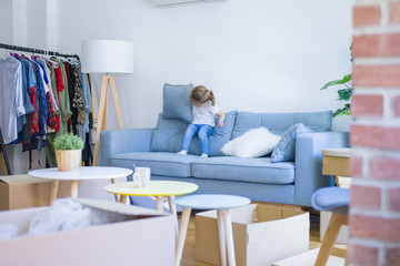 Beautiful toddler child girl jumping on the sofa