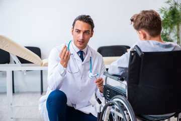 Young male doctor pediatrist and boy in wheel-chair