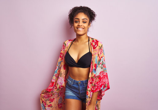 Young beautiful african american woman on vacation standing wearing bikini and colorful caftan