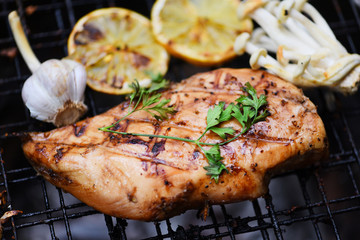 Chicken breast grilled with garlic chilli herbs and spices and lemon on grill top view - Roast BBQ chicken breast steak
