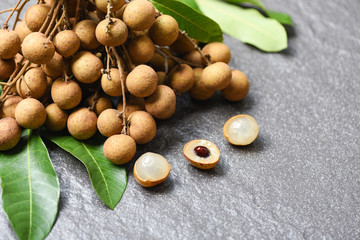 Longan fresh tropical fruit and green leaf in Thailand - Dimocarpus longan exotic fruits on black plate background