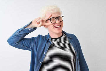 Young albino blond man wearing denim shirt and glasses over isolated white background Doing peace...