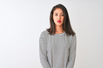 Young beautiful chinese woman wearing striped t-shirt standing over isolated white background Relaxed with serious expression on face. Simple and natural looking at the camera.