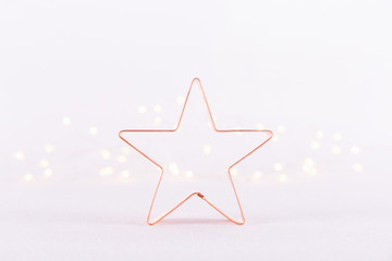 Star Copper cookie cutter on white sparkling background with bokeh lights. Holiday Christmas and New Year background. Horizontal