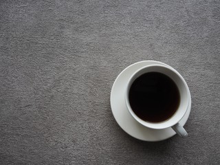 灰色の背景にコーヒーが入った白いカップ