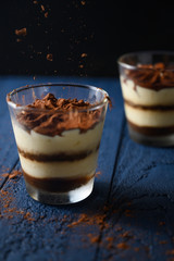 Tiramisu in a glass, sprinkled with chocolate. Freezing in motion.