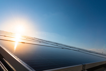 Solar panels and blue sky with light flare background.Solar cells farm on the roof.Photovoltaic...