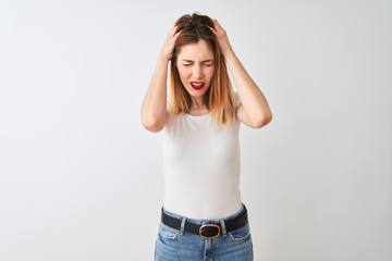 Beautiful redhead woman wearing casual t-shirt standing over isolated white background suffering from headache desperate and stressed because pain and migraine. Hands on head.