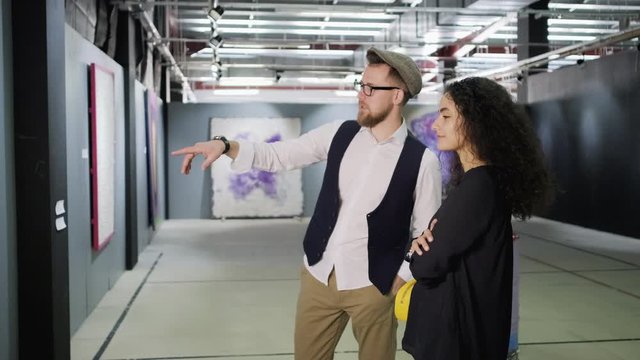 Young couple talking about the work of modern artist