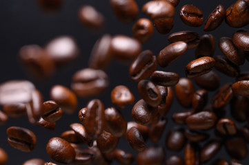 black coffee grains while cooking. Iced in the air on a black background for design