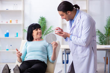 Fototapeta premium Old woman visiting young doctor dentist