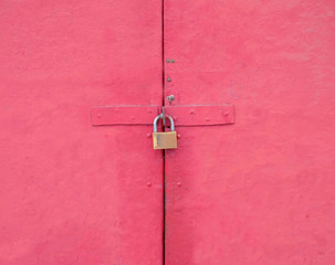 Pink door locked with a padlock.