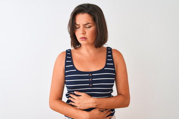 Obraz premium Young beautiful woman wearing blue striped t-shirt standing over isolated white background with hand on stomach because nausea, painful disease feeling unwell. Ache concept.