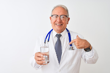 Senior grey-haired doctor man drinking glass of water over isolated white background with surprise face pointing finger to himself