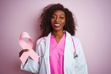 Young african american doctor woman holding cancer ribbon over isolated pink background with a...