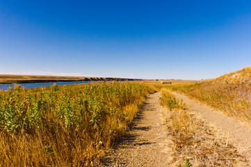 Gravel road along Bow river and prairie