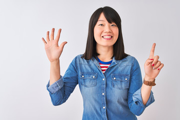 Young beautiful chinese woman wearing denim shirt over isolated white background showing and pointing up with fingers number six while smiling confident and happy.