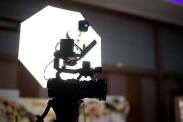 Modern digital television or video camera, camcorder, recorder in studio on blurred colorful...