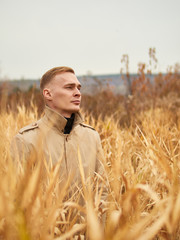 Autumn mood, young guy in a raincoat trench coat underground, street style.