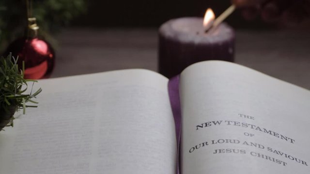 Lighting candle at Bible reading in Christmas background