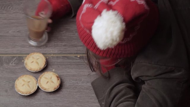 Woman wearing winter hat and gloves grabbing pies and coffee