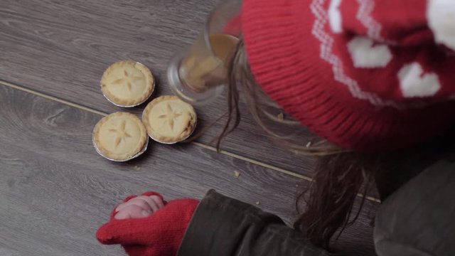 Woman wearing winter hat and gloves grabbing pies and coffee