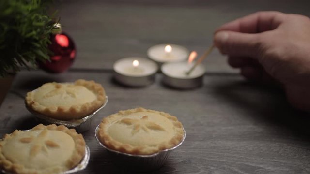 Christmas background lighting candles with baubles and mince pies