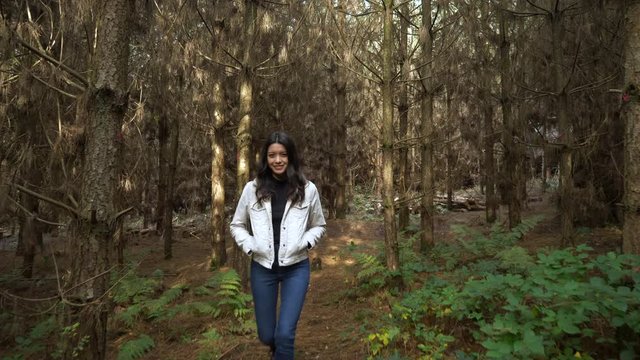 Smiling Woman Walks Through Enchanting Forest Landscape