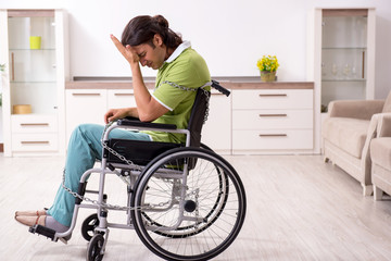 Young male invalid in wheel-chair suffering at home